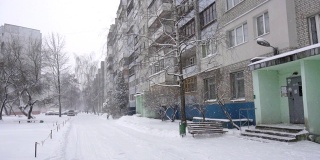 雪落在一座多层城市的住宅庭院里，背景、冬季、慢镜头