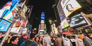 拥挤的人群，汽车交通和广告牌显示的广告在晚上在时代广场。美式生活方式或现代城市生活理念
