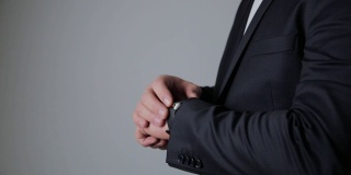 穿着黑色西装的商人看着他的智能手表。企业技术的概念