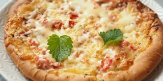 在家做披萨。把薄荷叶铺在新鲜烤好的玉米饼上，配上番茄和奶酪。