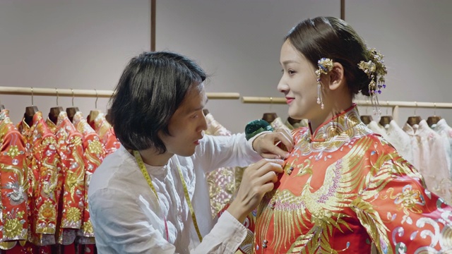 男中国婚纱设计师在工作室试穿年轻新娘