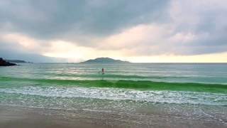 镜头从冲浪板上的女孩移到沙滩上视频素材模板下载