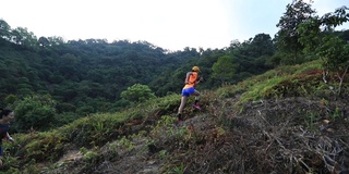 在热带森林的山坡上跑步的女人