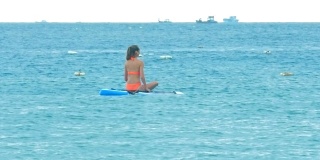 背部女人在比基尼划水板坐在船上