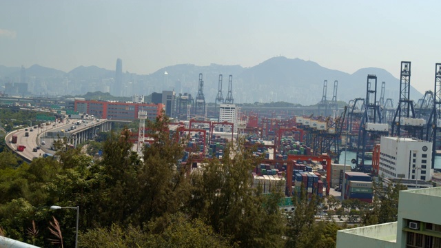 海运工业港口4K DCI与集装箱。进出口货物国际业务。大型起重机白天将集装箱卸到卡车上。