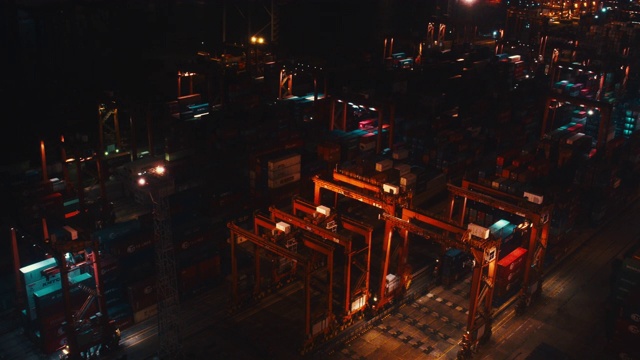 4K Dci实时运输工业港口与集装箱。进出口货物国际世界业务。大型起重机在夜间将集装箱卸上卡车。