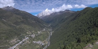 草原在风中飘扬，四姑娘山和蓝天在背景中。拍摄于前往海子沟的徒步路线上。