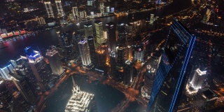 4k时间推移:航拍上海城市天际线全景，摩天大楼灯光秀和晚上的交通，中国。平移镜头