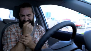 大胡子男子在开车时按摩手腕，受伤的手，关节发炎视频素材模板下载