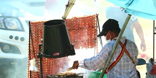 商人们坐在拖车上，旁边是卖米香肠的街头小吃