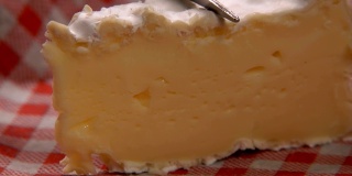 用叉子切一块松软的camambert奶酪