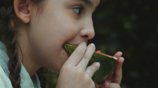 小女孩微笑着在户外吃西瓜视频素材模板下载