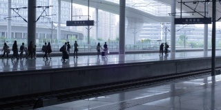 在中国的一个现代化火车站，乘客们在开出的站台上等待他们的高铁列车到达