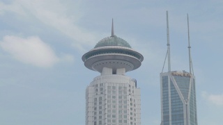 随着时间的流逝，中国上海市中心人民广场的丽笙大酒店和世茂国际广场上空的蓝天和白云视频素材模板下载