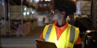 严肃的年轻非洲工人在仓库使用数字平板电脑