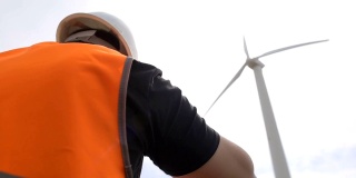 一名男性工程师正在对风力涡轮机进行检查和检查，风力涡轮机通过风力旋转叶片来发电，风力发电机，电力工业