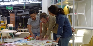 团队的创意设计师和建筑师工作在一个家庭商店的家庭装修使用蓝图和颜色样本