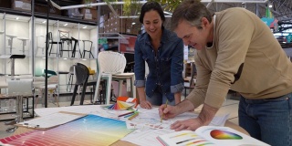 一对室内设计师正在做一个DIY项目，为一个家具店的草图上色