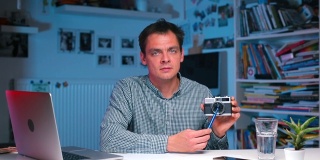 一所大学的摄影老师在展示一台旧相机。