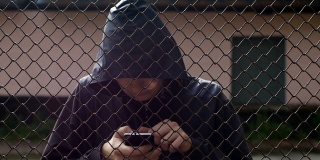 这个被囚禁的黑客站在监狱后面，爬进手机，侵入电脑程序，通过互联网偷窃，侵入账户