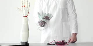 工程师正在测试机器人假肢手，通过传感器重复他的手在手套中的运动