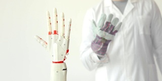 科学家正在测试机器人假肢手，通过传感器重复他的手在手套里的运动。肌肉神经移植技术