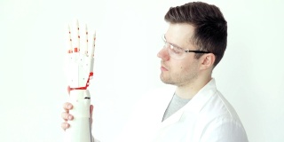 工程师科学家正在专心研究和测试机器人假肢手，它可以用手指进行程序化的运动