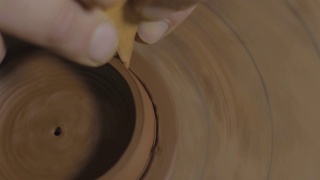 工匠用木刀将宜兴陶土壶盖上多余的陶土取出。茶道用手工陶壶。褐色陶器茶壶。4 k的视频。59.94帧/秒视频素材模板下载