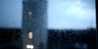 大雨伴随着闪电和风，窗外是飓风。城市的夜晚天气。雨滴顺着玻璃流下，时光流逝，复制空间
