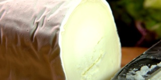 用刀切成薄片的山羊奶酪的特写