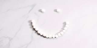 白色大理石背景上的微笑形状的棉花糖静止运动