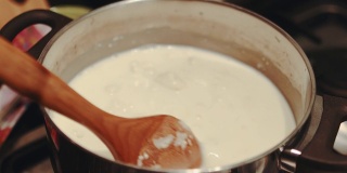 准备小麦粉布丁-用牛奶煮细小麦粉，用木勺搅拌
