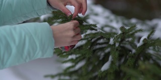一位年轻女子在森林里装饰圣诞树