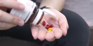 SLO MO从手边的药瓶中服用许多药物或维生素