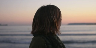 日落时分沙滩上一位年轻女子的肖像。她玩得很开心