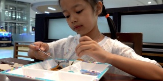一个亚洲女孩在餐厅吃日式炒面。