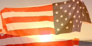 举着美国国旗和日落的人