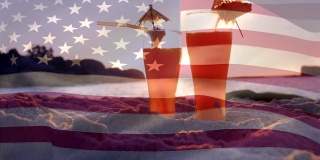 海滩上的两杯鸡尾酒和7月4日的一面美国国旗