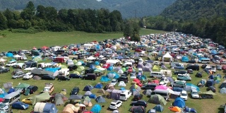 无人机拍摄的是一个绿色茂盛的山区音乐节的露营地。