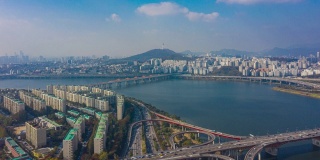 韩国首尔市区天际线，高速公路上的车辆和横跨汉江的大桥。