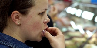 一个年轻的女人品尝土耳其糖果在一个商店度假的特写。