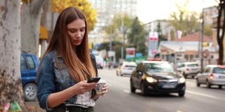 侧面的美丽的年轻女子拿着智能手机和使用出租车服务的应用程序