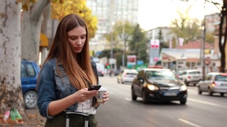 侧面的美丽的年轻女子拿着智能手机和使用出租车服务的应用程序视频素材模板下载