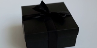 节日礼物在黑色美丽的盒子在白色的背景。优雅的黑色节日盒与缎带。