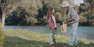 爷爷和孙女在给植物浇水