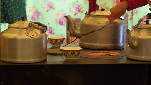 在中国青海省拉积山的一个帐篷里，用金属茶壶泡茶。