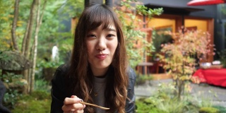年轻女子吃“anmitsu”日本糖果
