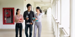 三个学生在学校走廊里散步聊天。