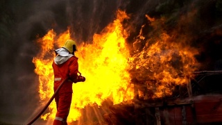一名勇敢的消防队员用螺旋形水龙带扑灭一场车祸中的大火的慢镜头视频素材模板下载