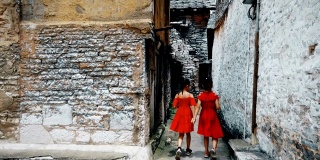 中国贵州安顺，小女孩们在一条老胡同里散步。